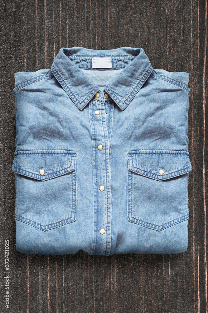 Denim shirt on wooden background Denim shirt on wooden background