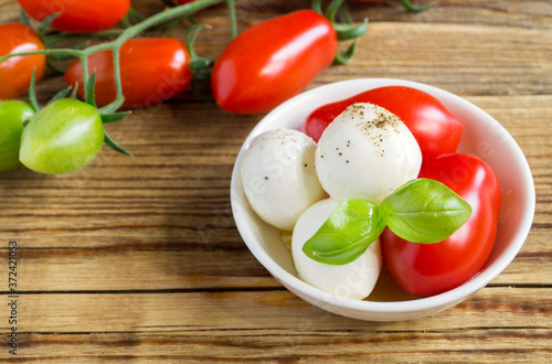 Caprese salad with ripe tomatoes and mozzarella with fresh Basil leaves.