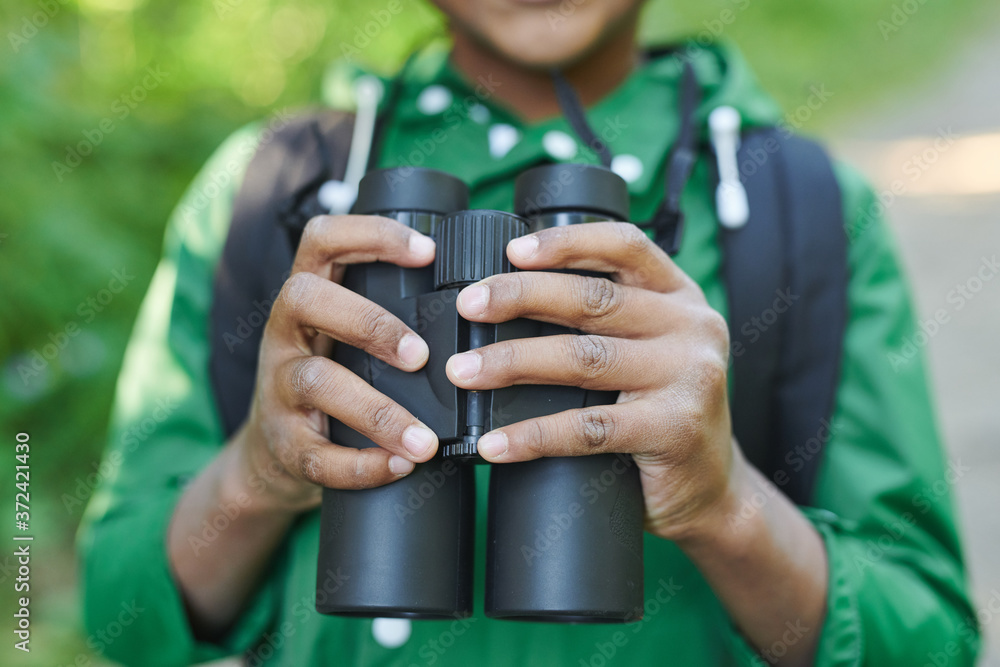 Close-up of boy holding binoculars while travelling outdoors Close-up of boy holding binoculars while travelling outdoors