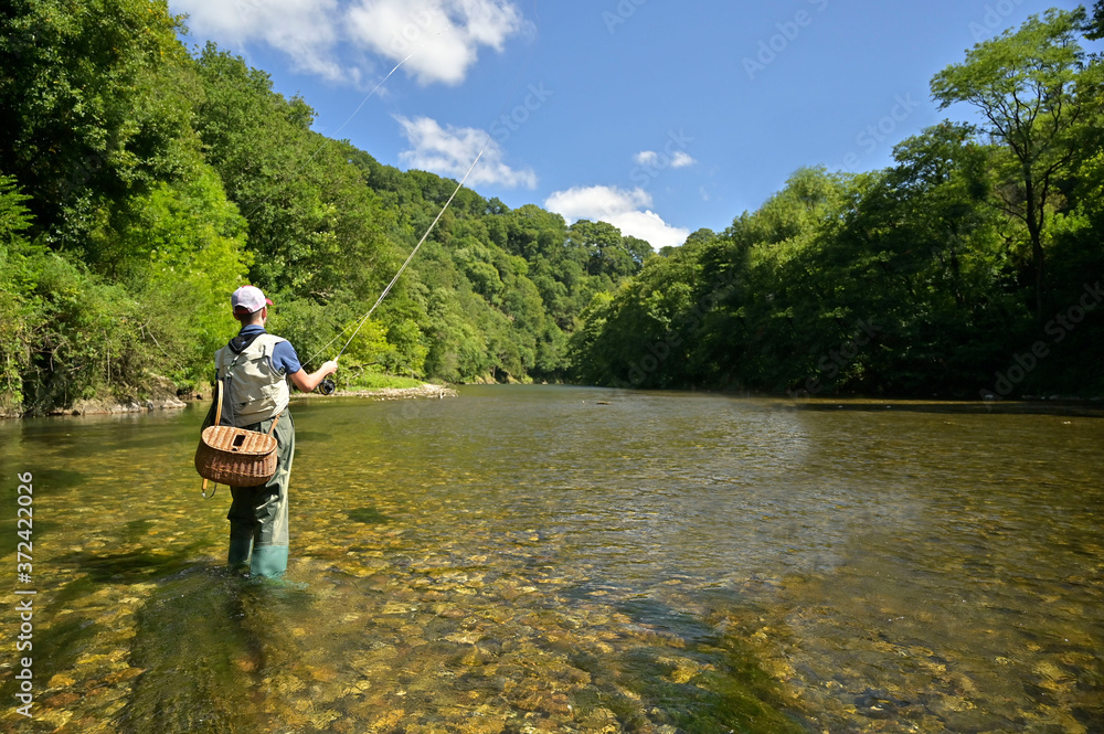 jeune garçon pêchant à la moucheen été dans une belle rivière à l'eau claire jeune garçon pêchant à la moucheen été dans une belle rivière à l'eau claire