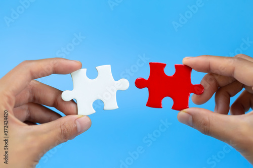 Two hands of businessman to connect couple puzzle piece. symbol of association and connection. business strategy.