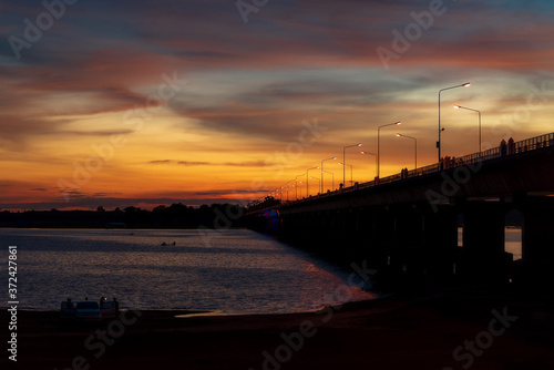 Silhouette of a bridge stretching across a twilight river at Lam Pao Dam, Kalasin Province, Thailand © weerachai