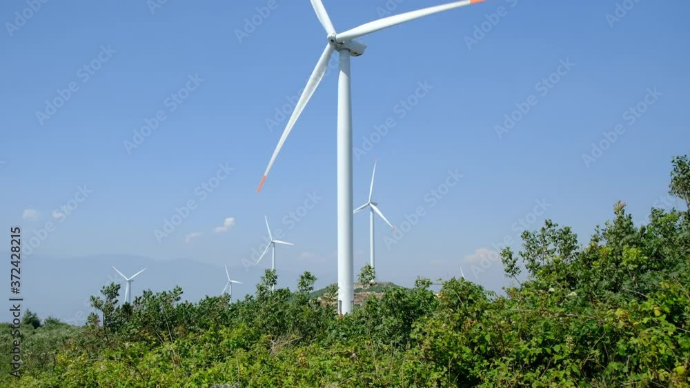 Wind mills, clouds and blue sky. Camera tilting up. Wind power turbines generating renewable clean energy. Wind mills, clouds and blue sky. Camera tilting up. Wind power turbines generating renewable clean energy.
