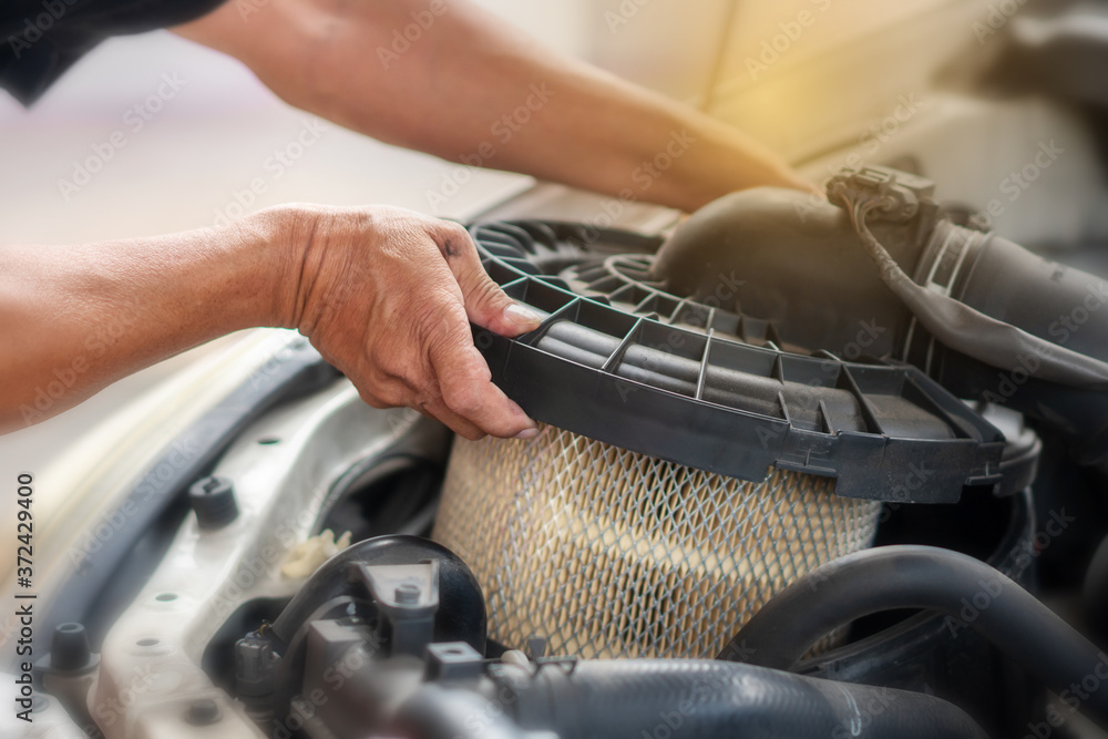 Car mechanic working in repair garage. maintenance checking air filter Car mechanic working in repair garage. maintenance checking air filter