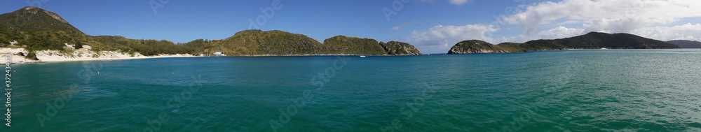 Panoramic shot of a blue sea surrounded by mountains in Brazil