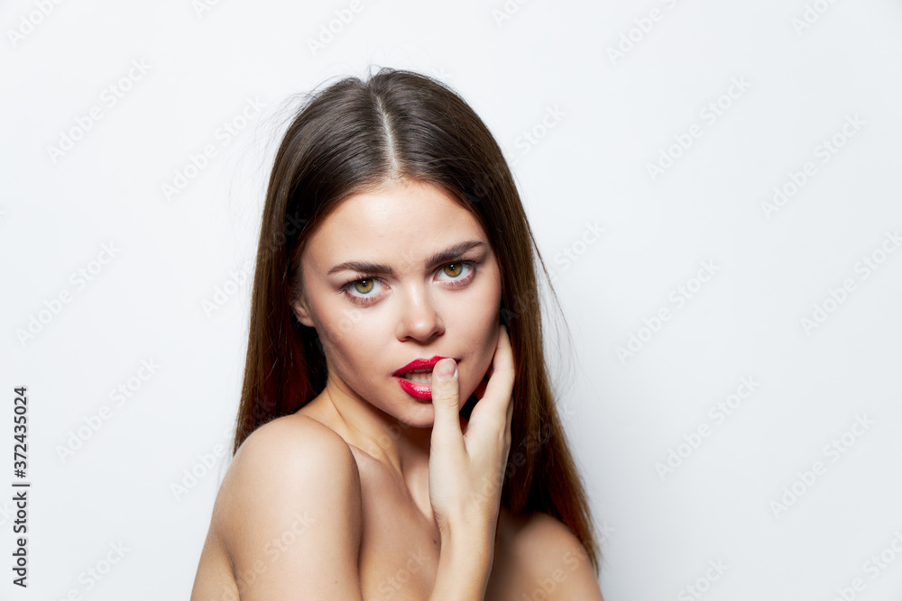 Charming woman Bare shoulders holds a hand on face charm red lips Charming woman Bare shoulders holds a hand on face charm red lips