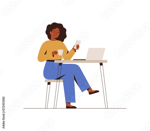 Black Woman chatting on a smartphone sitting at the cafe table. Happy freelancer or office female working remotely use a laptop. African girl looking at the phone, drinking coffee at the workplace.