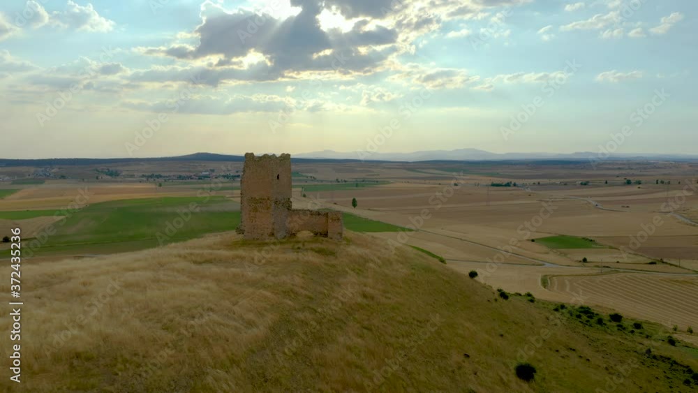 Flying Towards The Castle Of La Torresaviñan On Top Of The Hill With A Beautiful Sky And Sunlight Above The Fields In La Torresaviñán, Spain.  - aerial drone