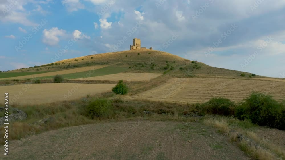 Rural Field On The Countryside Overlooking The Castle Of La Torresaviñan On The High Hill Against The Blue Sky In The Hamlet Of La Torresaviñán, Spain. - aerial drone Rural Field On The Countryside Overlooking The Castle Of La Torresaviñan On The High Hill Against The Blue Sky In The Hamlet Of La Torresaviñán, Spain. - aerial drone