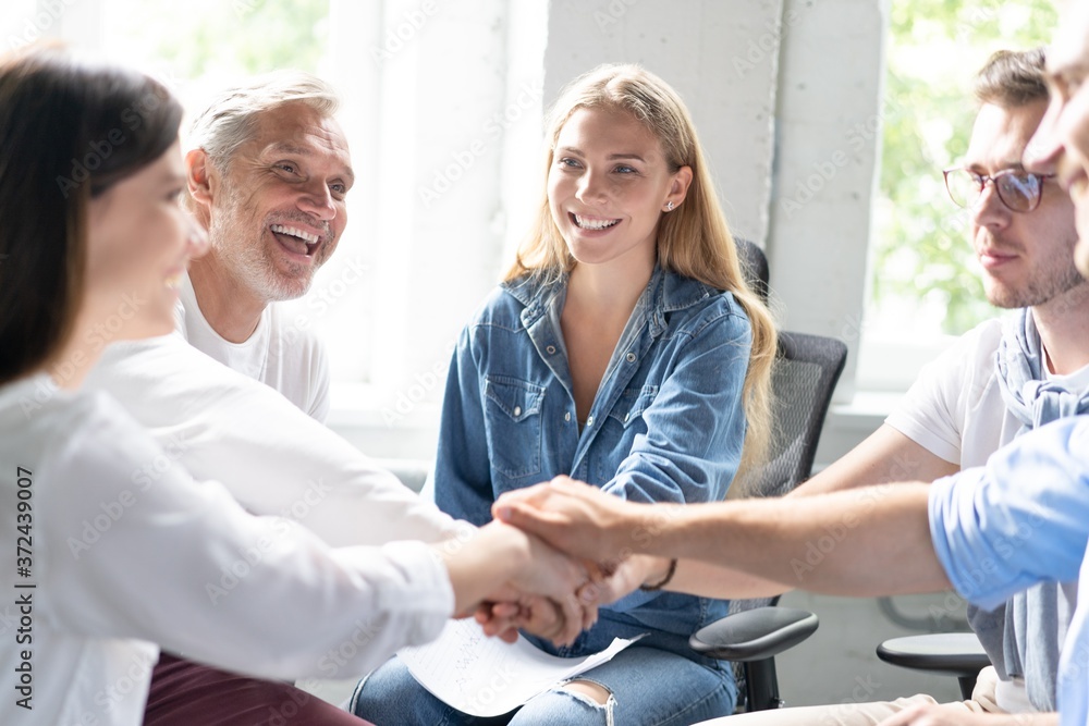 Obraz premium Happy business team making high five with their hands in the office