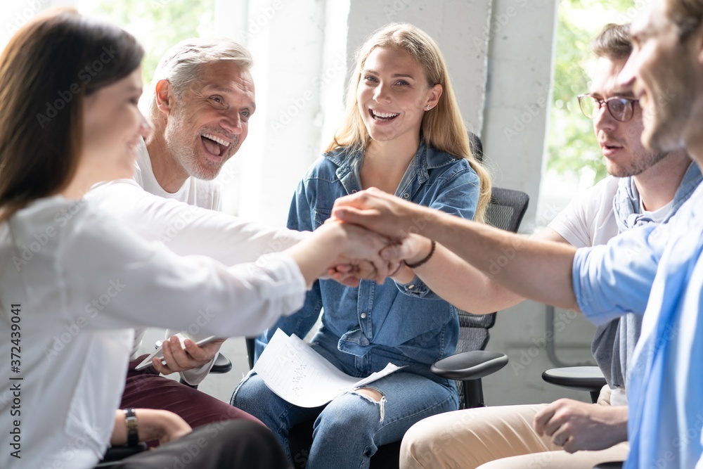 Obraz premium Happy business team making high five with their hands in the office