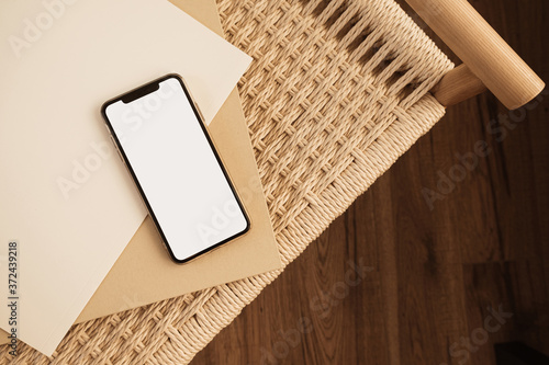 Blank screen smartphone and wicker bench. Flat lay, top view empty copy space mockup template photo