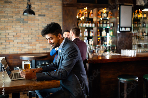 Handsome young business man  blogger or remote working with laptop in bar
