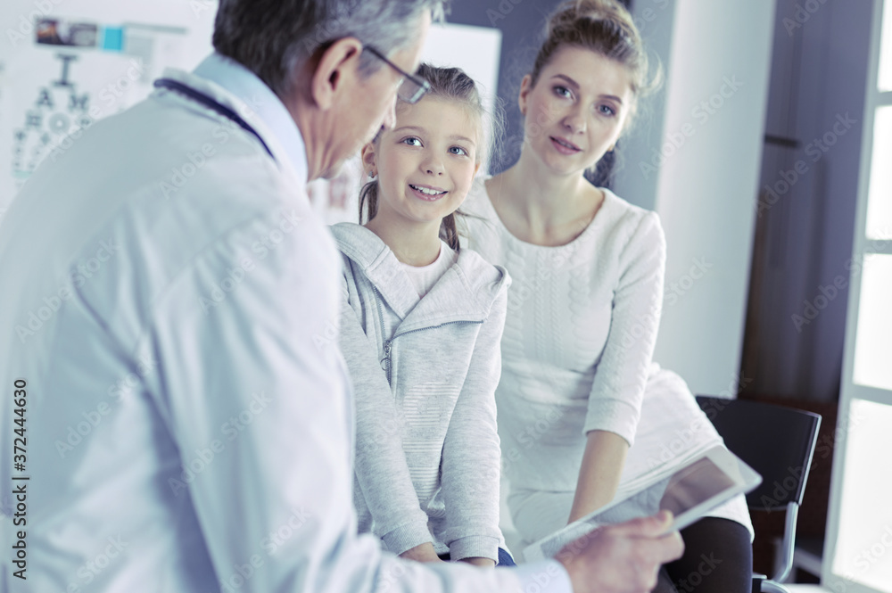 Fototapeta premium Little girl with her mother at a doctor on consultation