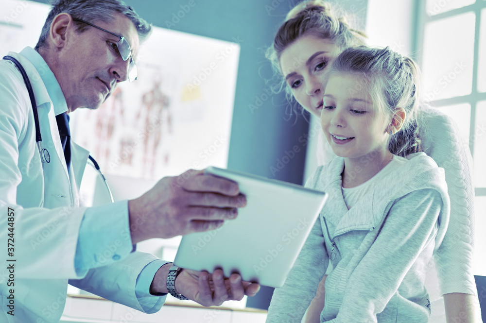 Fototapeta premium Little girl with her mother at a doctor on consultation