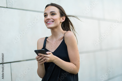 Young beautiful woman with smartphone. Outdoor lifestyle portrait Free Download Young beautiful woman with smartphone. Outdoor lifestyle portrait - GFXLoad