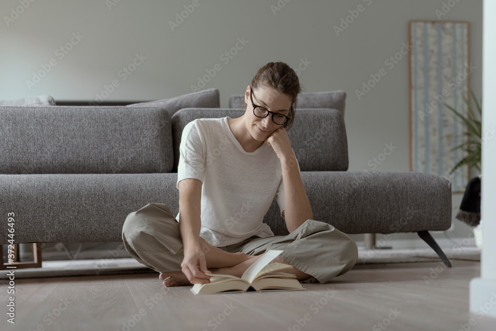 Woman relaxing at home and reading a book Woman relaxing at home and reading a book