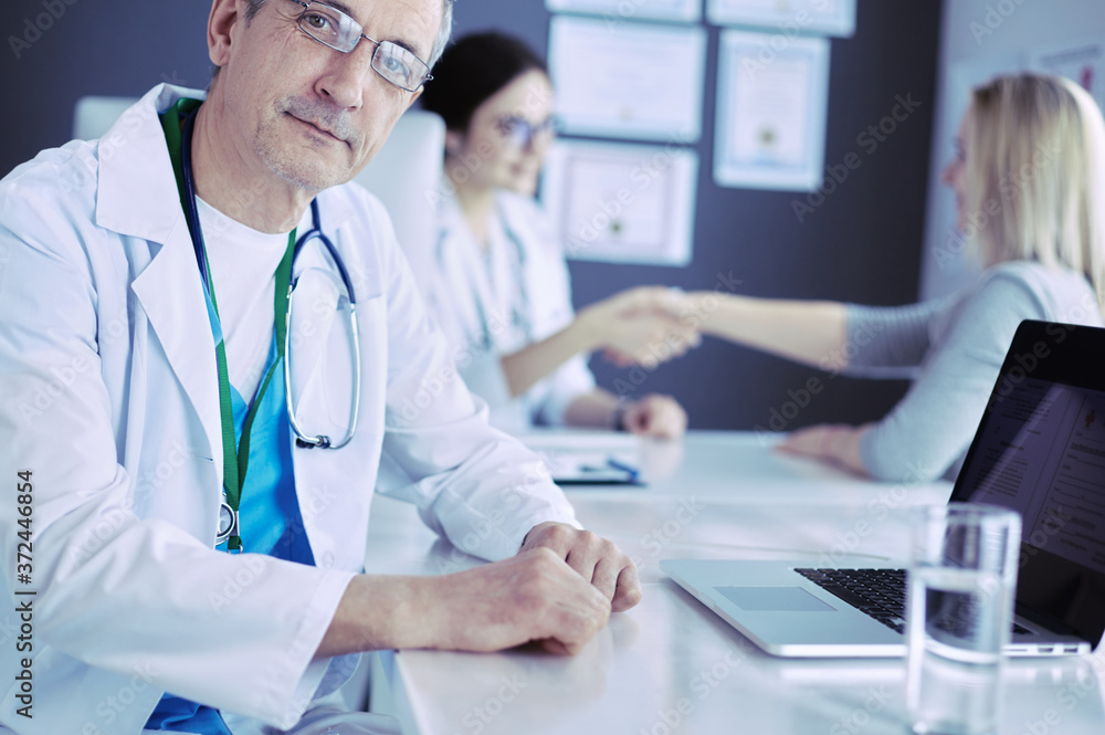 Doctor and patient discussing something while sitting at the table . Medicine and health care concept Doctor and patient discussing something while sitting at the table . Medicine and health care concept