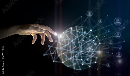 The businessman's hand touches the global network of connecting clients to data, against the background of space. Concept of innovative technologies. Elements of this image are provided by NASA