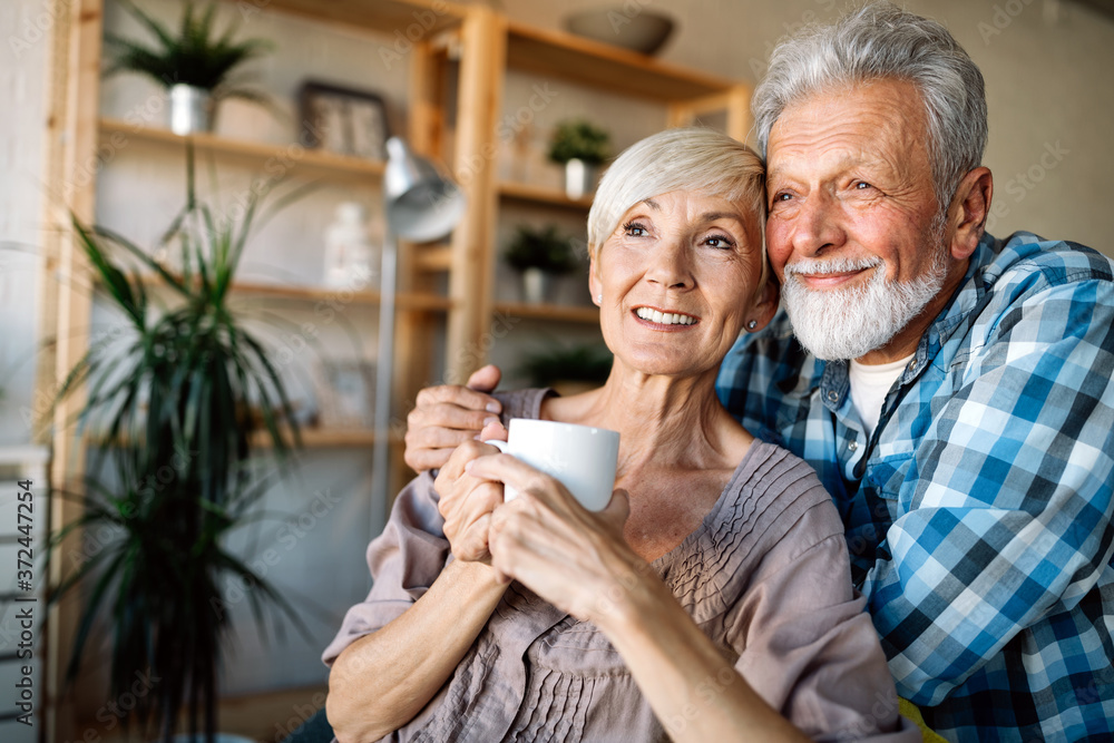 Happy smiling senior couple embracing together at home Happy smiling senior couple embracing together at home