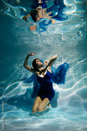 Woman in blue dress under water.