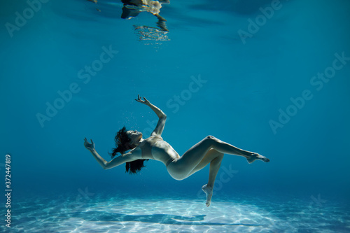 A woman with nice body dancing under water.Underwater photo