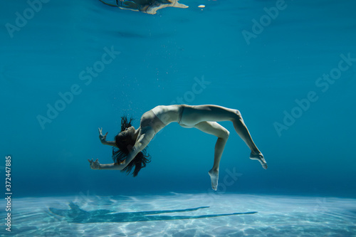 A woman with nice body dancing under water.Underwater photo