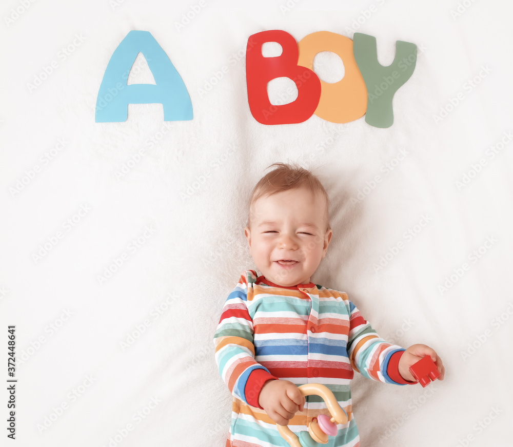 Baby boy lying on the blanket with letters above Baby boy lying on the blanket with letters above