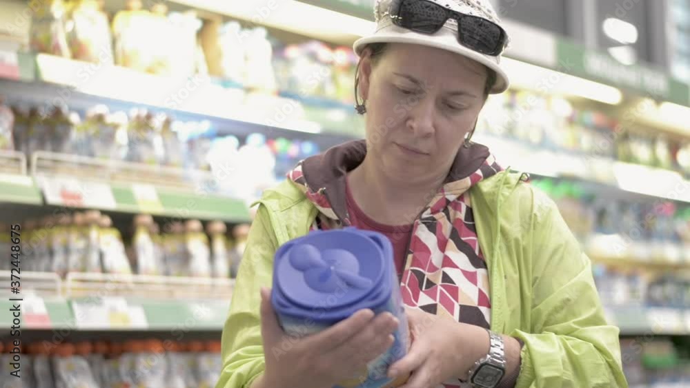 Woman in the store chooses a dry mix for a child, carefully reads the composition of the product. Woman in the store chooses a dry mix for a child, carefully reads the composition of the product.