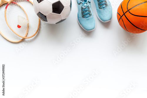 Flat lay of sport balls and rackets on white background. Above view  copy space