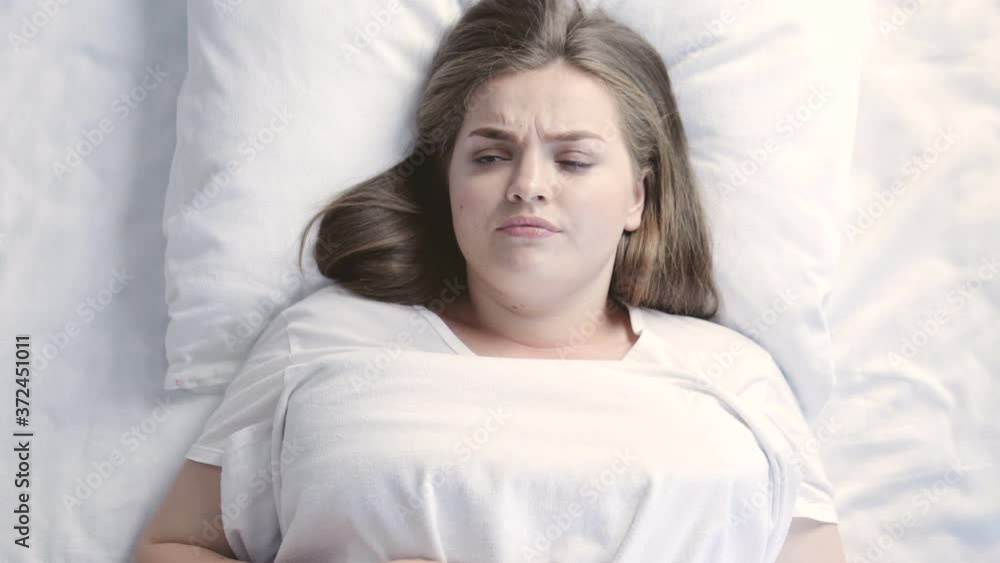 Lonely woman adjusting blanket lying in bed cant fall asleep because of thoughts Lonely woman adjusting blanket lying in bed cant fall asleep because of thoughts