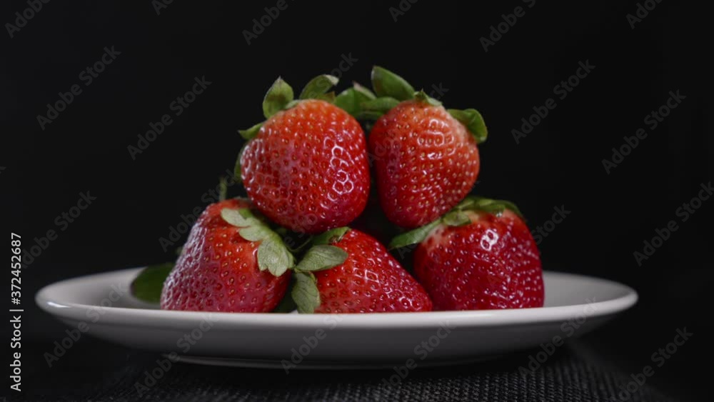 Pan down to a plate of rich juicy delicious strawberries Pan down to a plate of rich juicy delicious strawberries
