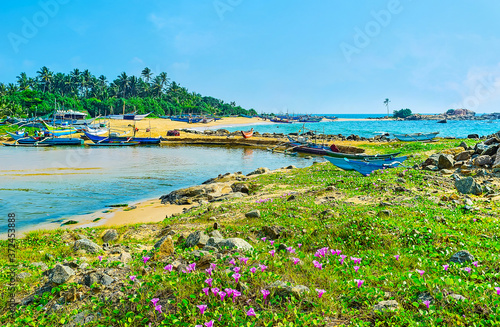 The coast of Hikkaduwa with oruwa boats in Dodanduwa Harbor, Sri Lanka photo