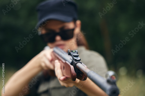 Woman on nature Holding a gun sight hunting green leaves green trees