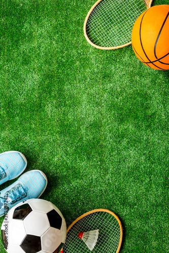 Sport games equipment on football field - balls  sneakers  rackets. Top view