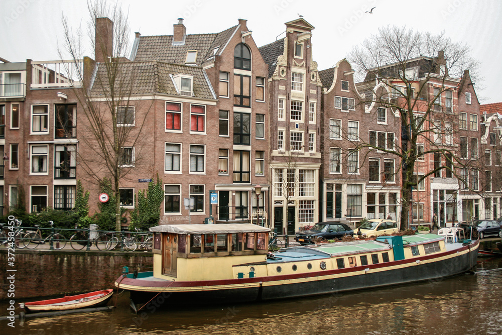 Amsterdad Canal, with boats and houses on both sides of the river and houses around