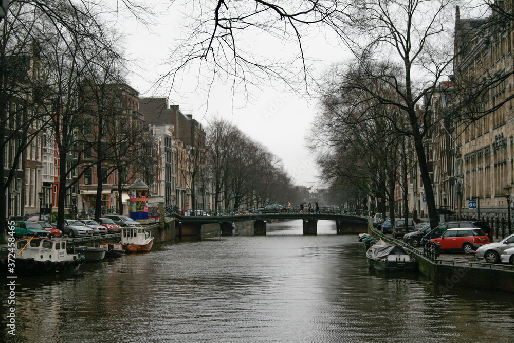 Amsterdad Canal, with boats and houses on both sides of the river and houses around