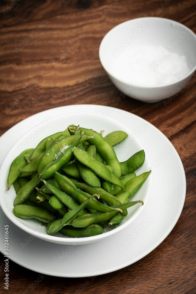 edamame beans snack in bowl on table with sea salt edamame beans snack in bowl on table with sea salt