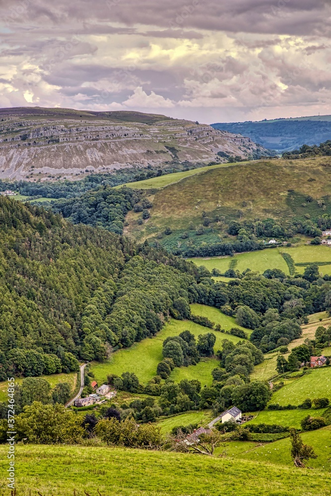 View from Horseshoe Pass, Llantysilio, North Wales showing farmland pastures, forest, moorlands and stone escarpment. 