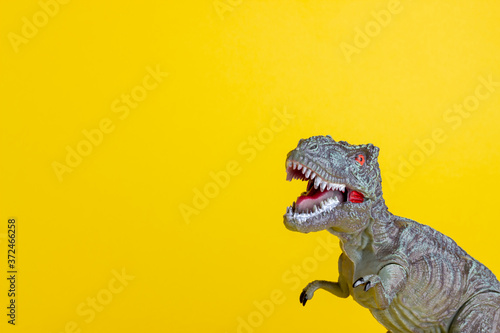 Dinosaur on a yellow background. Toy. Creative idea. Concept. © Vladislav Chusov