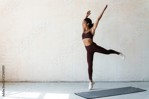 Portrait of young african american woman doing workout on mat in room
