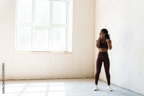 Portrait of young african american woman in bright room doing workout
