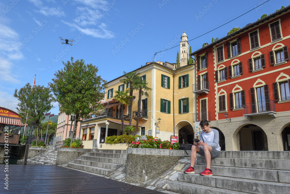 Naklejka premium Boy flying a drone at Morcote on Switzerland
