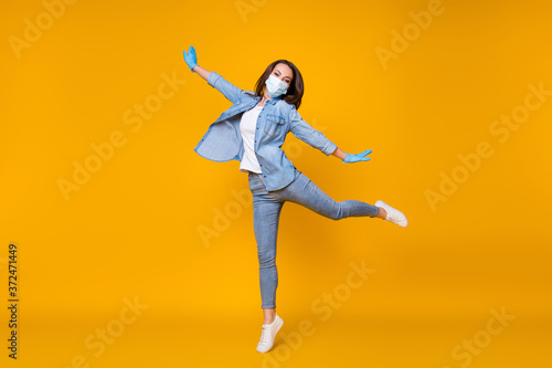 Full length body size view of her she nice attractive careless healthy girl wearing safety gauze mask jumping stop disease dancing isolated bright vivid shine vibrant yellow color background