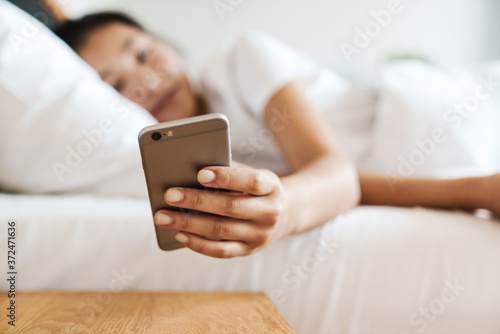 Attractive young asian woman holding smartphone