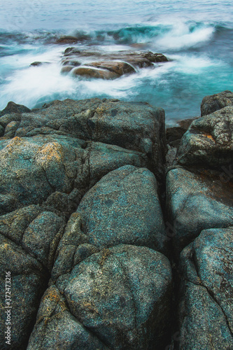 Rocky sea shore, cliffs with surf on the Gamova Peninsula in the Primorsky territory, seascape of Russia. photo