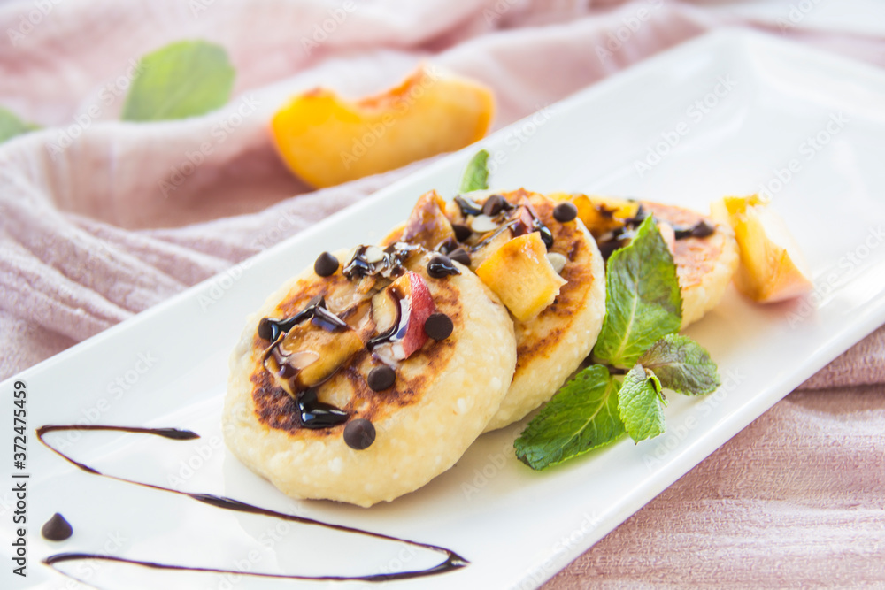 A healthy breakfast of pancakes, peach, chocolate, and honey A healthy breakfast of pancakes, peach, chocolate, and honey