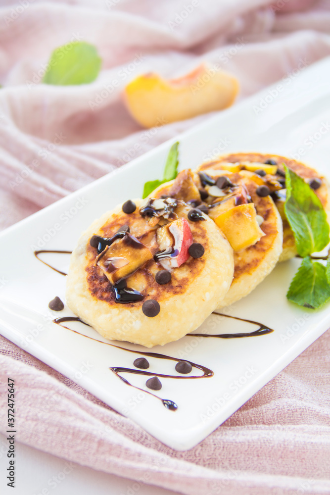 A healthy breakfast of pancakes, peach, chocolate, and honey A healthy breakfast of pancakes, peach, chocolate, and honey