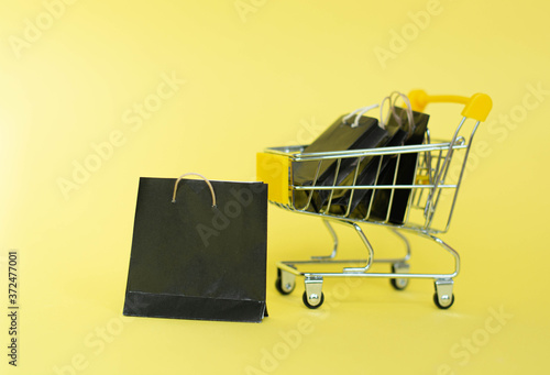 close-up of shopping trolley on yellow background with some copy space