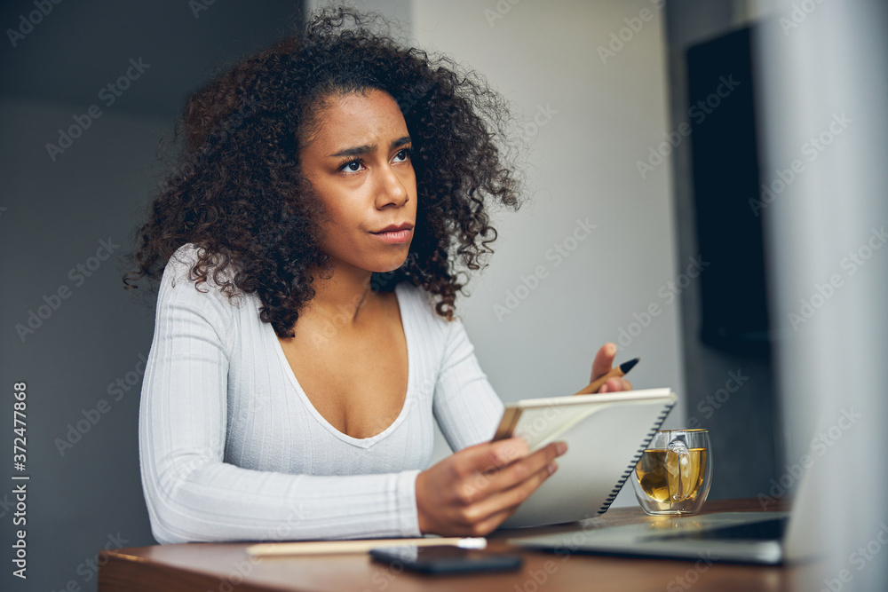 Beautiful woman with curly hair holding notebook Beautiful woman with curly hair holding notebook